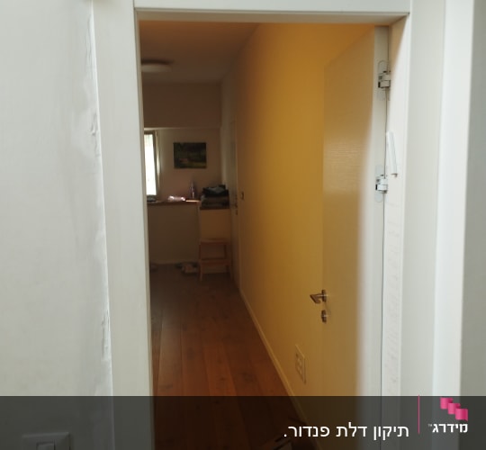 דלת לבנה פתוחה עם ידית מתכת